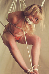 Topless blonde - suspended in rope
